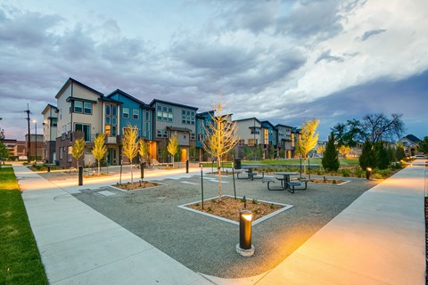a park with benches and trees in front of a building